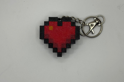 Pixelated heart-shaped keychain on a white background